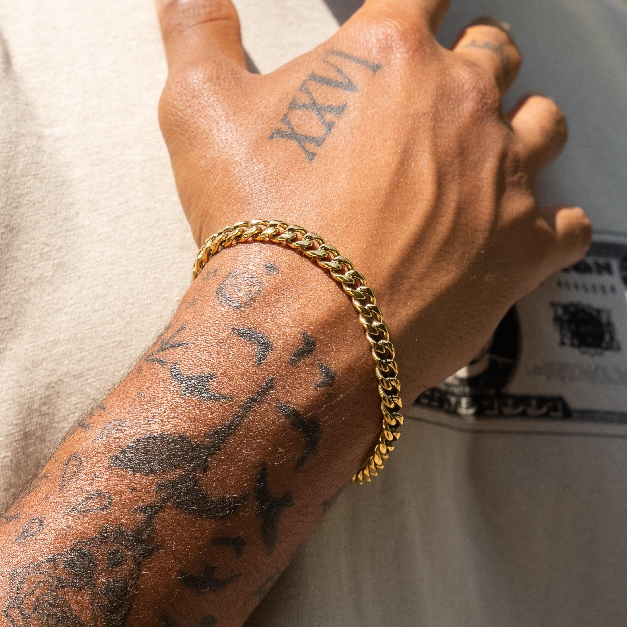 6mm gold Cuban bracelet on tattooed wrist.