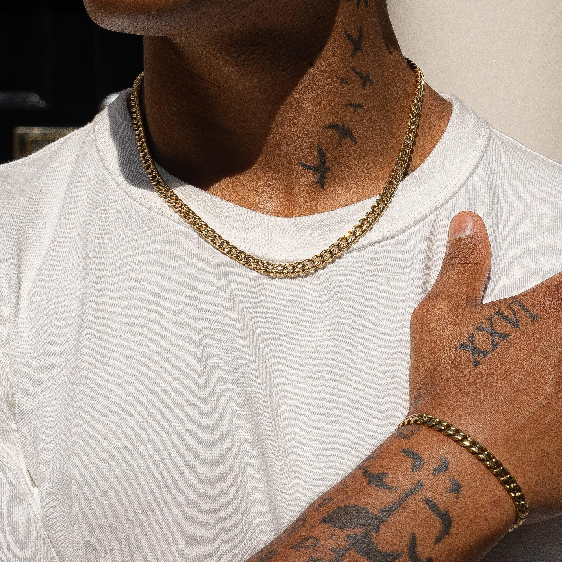 6mm gold Cuban chain and bracelet set on model wearing a white t-shirt.