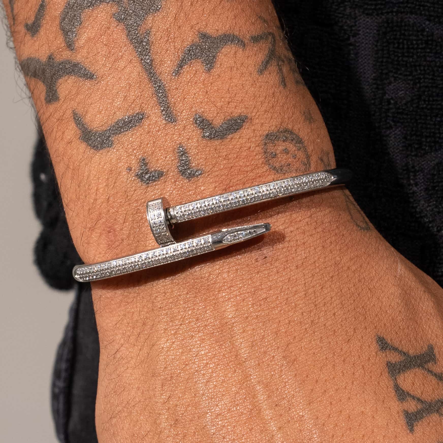 Iced Nail Bracelet in white gold on tattooed wrist, 18K PVD vacuum plated.