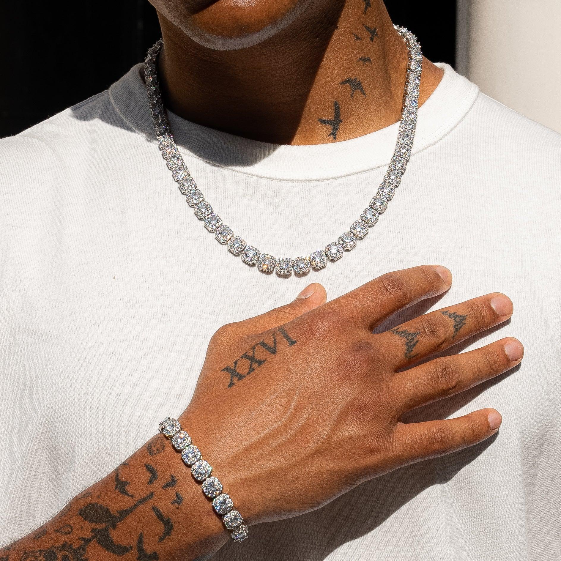 10mm clustered tennis chain and bracelet in white gold with diamond simulants, worn by a person.